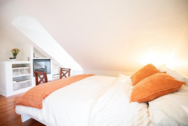 bedroom featuring wood finished floors and lofted ceiling