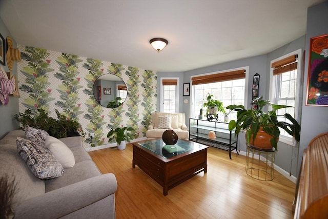 living room with wallpapered walls, baseboards, and wood finished floors