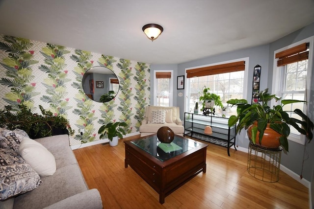 living room with wallpapered walls, plenty of natural light, baseboards, and wood finished floors