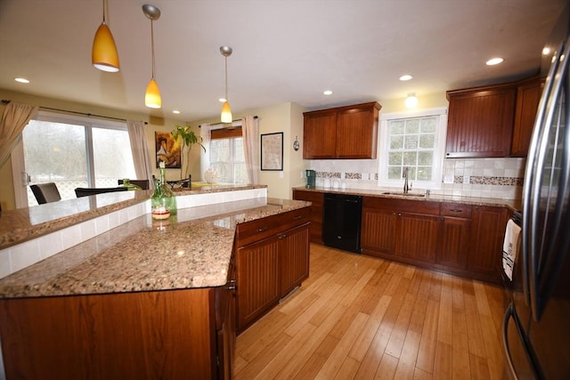 kitchen featuring a sink, light wood-style floors, backsplash, freestanding refrigerator, and dishwasher