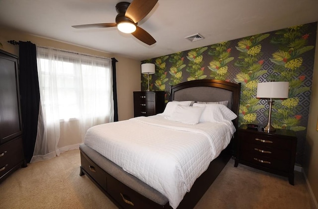 bedroom featuring wallpapered walls, baseboards, visible vents, light colored carpet, and ceiling fan