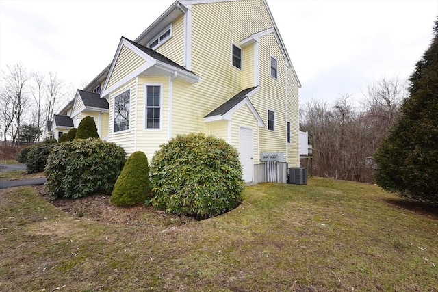 view of property exterior with cooling unit and a yard