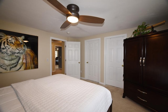 bedroom with light colored carpet, ceiling fan, and baseboards