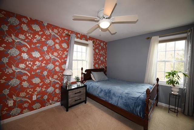 bedroom featuring light carpet, wallpapered walls, baseboards, and a ceiling fan