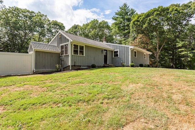 70 Oak St, Norton, MA 02766 - view of front of home with roof with shingles, board and batten siding, view of wooded area, and a chimney