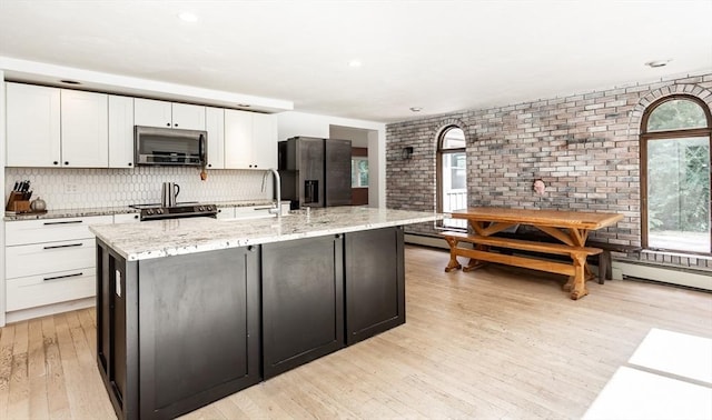 70 Oak St, Norton, MA 02766 - kitchen with stainless steel microwave, refrigerator with ice dispenser, plenty of natural light, white cabinets, and recessed lighting
