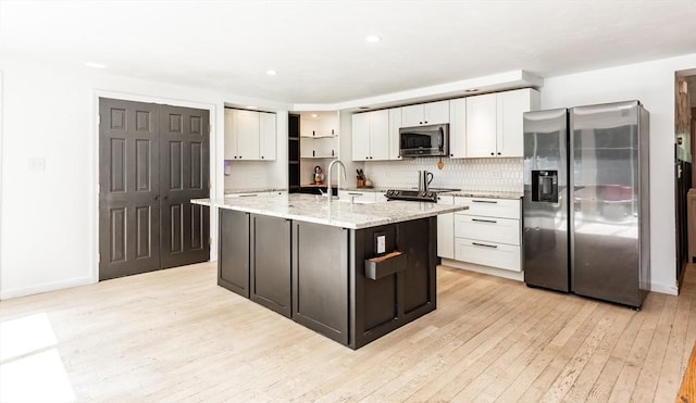 70 Oak St, Norton, MA 02766 - kitchen with stainless steel appliances, light wood finished floors, white cabinets, light stone counters, and recessed lighting