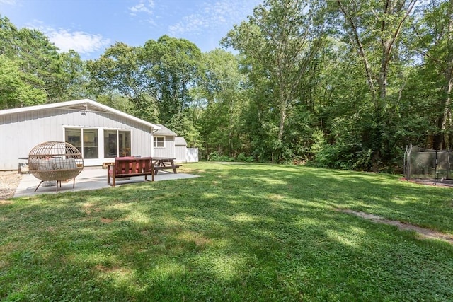70 Oak St, Norton, MA 02766 - view of grassy yard featuring a patio and a trampoline