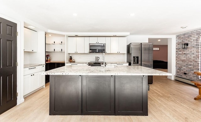 70 Oak St, Norton, MA 02766 - kitchen featuring stainless steel appliances, open shelves, white cabinetry, a baseboard radiator, and a center island with sink
