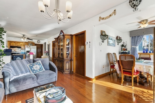 living room with ceiling fan with notable chandelier and light hardwood / wood-style floors