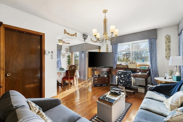 living room featuring hardwood / wood-style flooring, plenty of natural light, and ceiling fan with notable chandelier