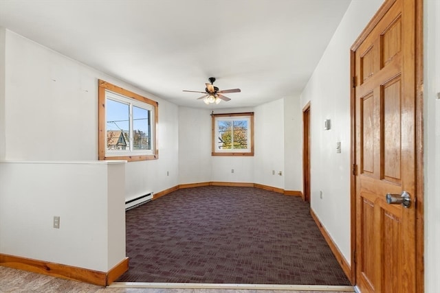 carpeted spare room featuring ceiling fan and a baseboard radiator