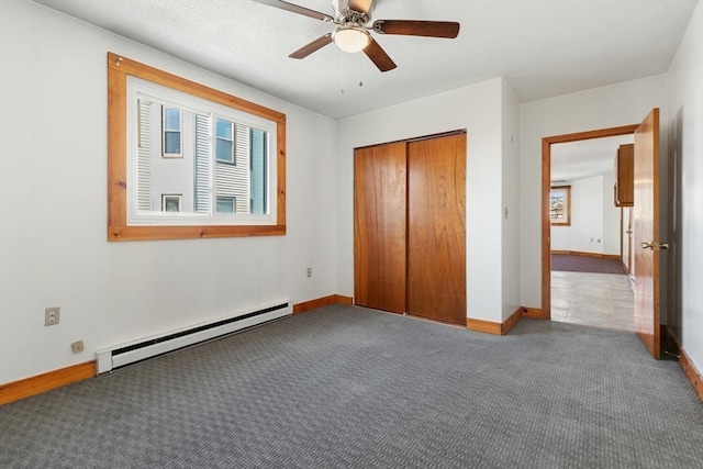 unfurnished bedroom featuring carpet, ceiling fan, a closet, and a baseboard heating unit