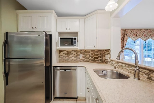 80 Summer St, Walpole, MA 02071 - kitchen featuring appliances with stainless steel finishes, a sink, decorative backsplash, white cabinetry, and light stone countertops