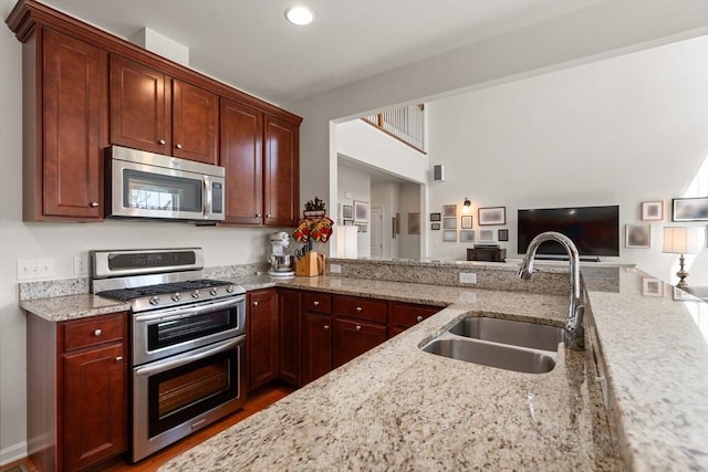 8 Heartwood Way Unit 8, Hopkinton, MA 01748 - kitchen with stainless steel appliances, a sink, light stone counters, open floor plan, and wood finished floors