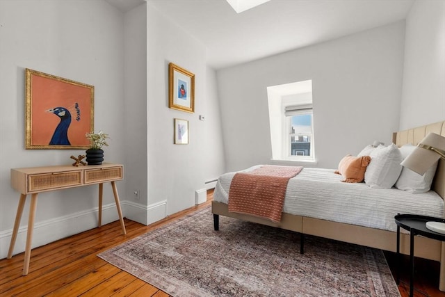 bedroom featuring wood-type flooring and a skylight