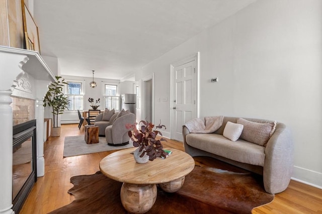 living room featuring baseboard heating and light hardwood / wood-style floors