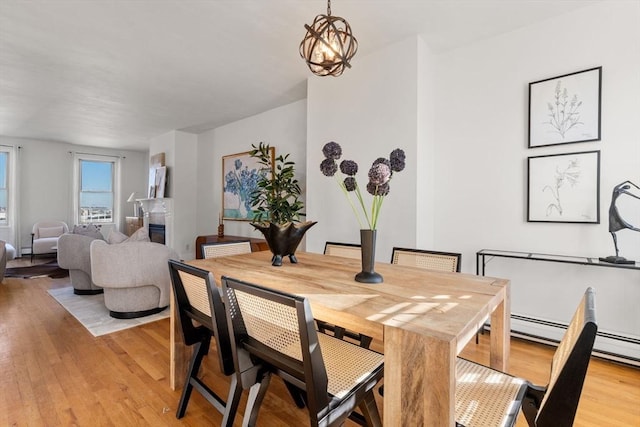 dining space with a notable chandelier and light hardwood / wood-style flooring