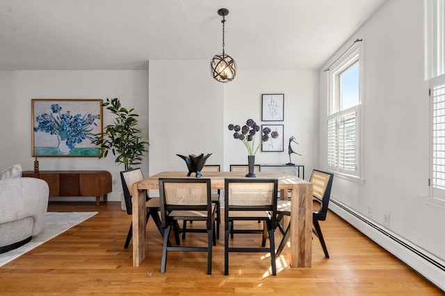 dining area with a baseboard heating unit and light hardwood / wood-style floors