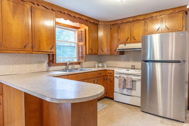 59 Mountain Rd, Holyoke, MA 01040 - kitchen with freestanding refrigerator, electric range, under cabinet range hood, brown cabinets, and a peninsula