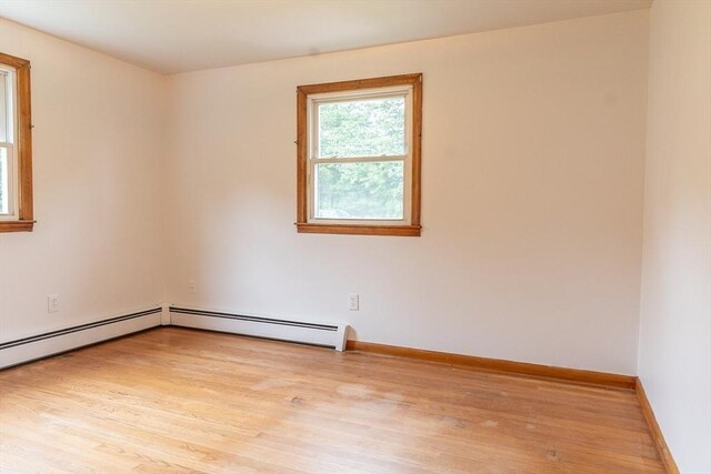 59 Mountain Rd, Holyoke, MA 01040 - empty room with light wood finished floors and a baseboard radiator