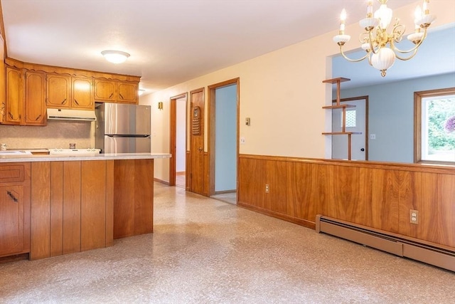 59 Mountain Rd, Holyoke, MA 01040 - kitchen with freestanding refrigerator, brown cabinetry, a baseboard radiator, under cabinet range hood, and light countertops