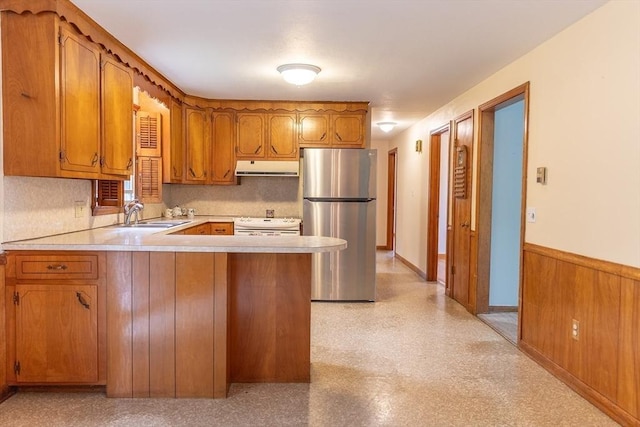 59 Mountain Rd, Holyoke, MA 01040 - kitchen featuring freestanding refrigerator, under cabinet range hood, brown cabinets, light countertops, and a peninsula