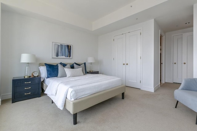 bedroom featuring light colored carpet and a closet