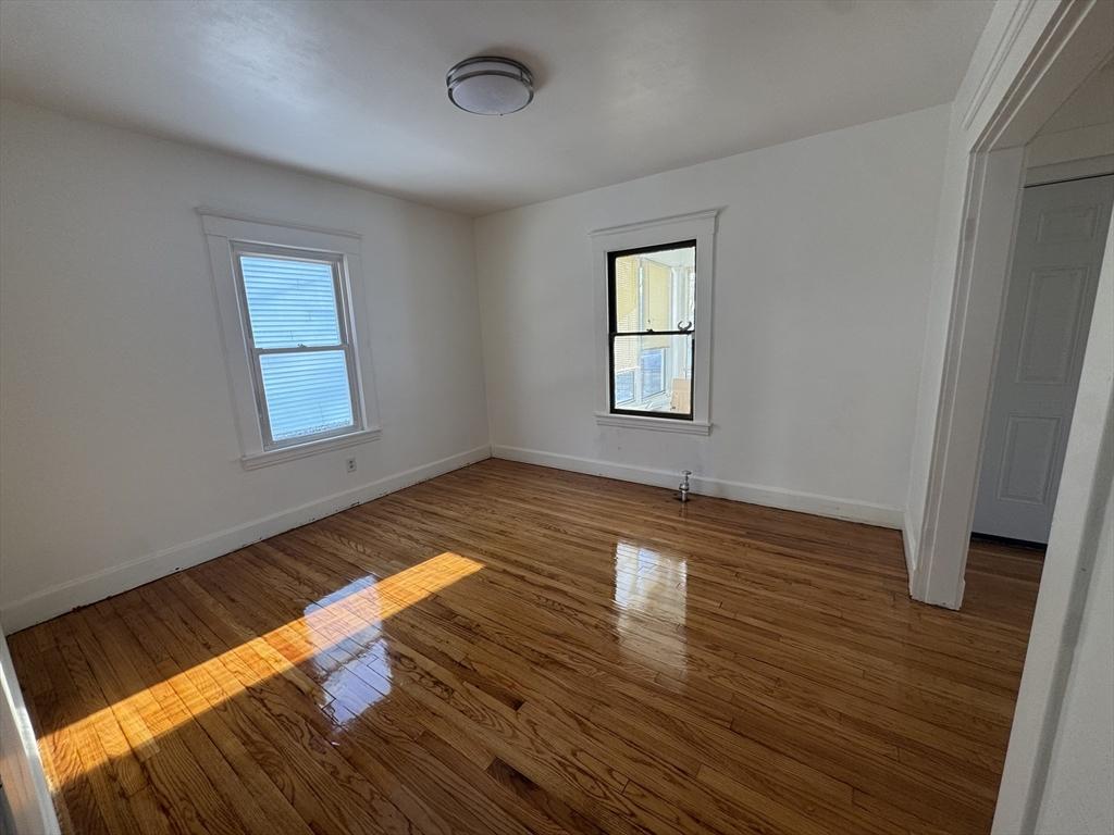 unfurnished room featuring dark wood-type flooring and plenty of natural light