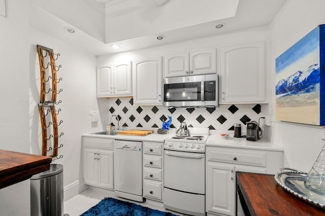 kitchen with white appliances, wooden counters, tasteful backsplash, recessed lighting, and a sink