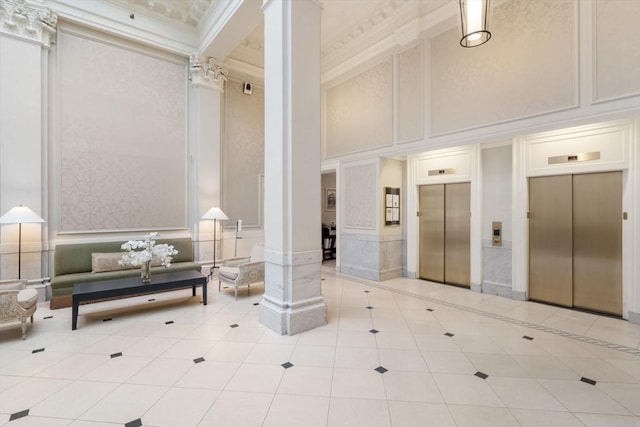 lobby with a decorative wall, a high ceiling, and crown molding