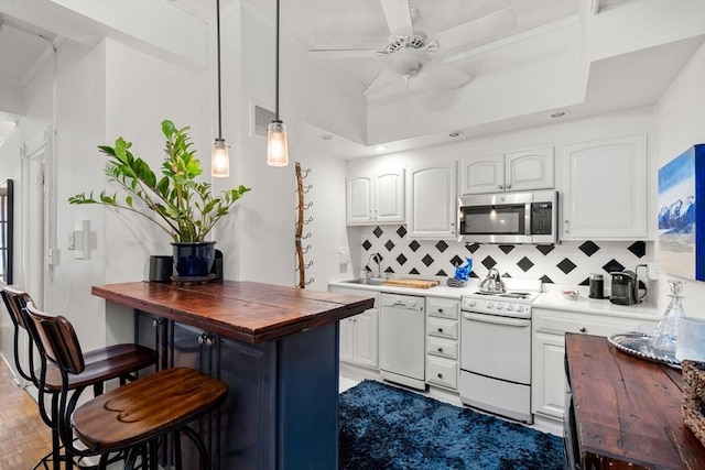 kitchen featuring white appliances, butcher block countertops, decorative backsplash, ceiling fan, and white cabinets