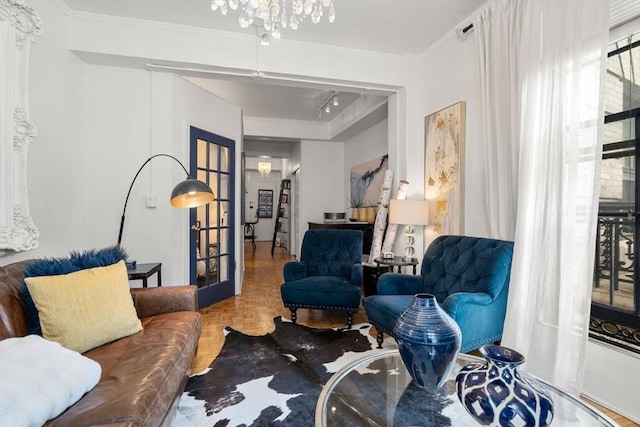 living room with a chandelier, crown molding, french doors, and healthy amount of natural light