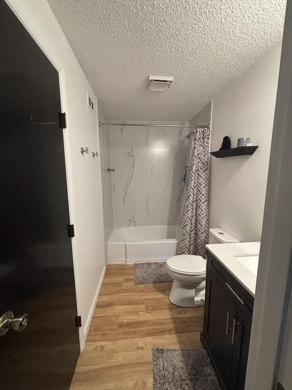 full bathroom featuring hardwood / wood-style floors, vanity, shower / tub combo, and a textured ceiling