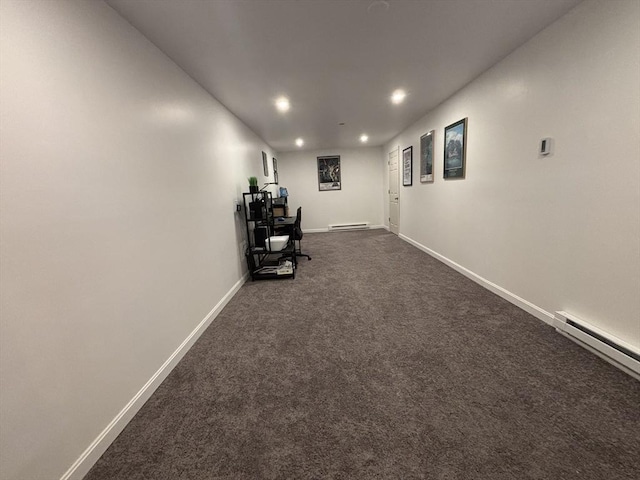 hall with dark carpet and baseboard heating