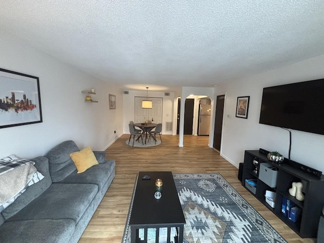 living room with wood-type flooring and a textured ceiling