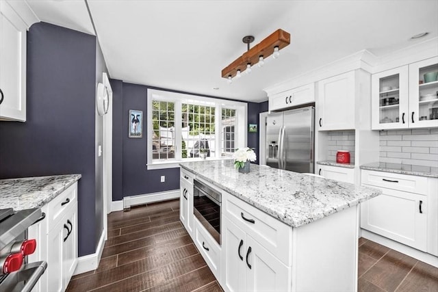 685 Highland St, Marshfield, MA 02050 - kitchen with appliances with stainless steel finishes, glass insert cabinets, baseboard heating, white cabinetry, and decorative backsplash
