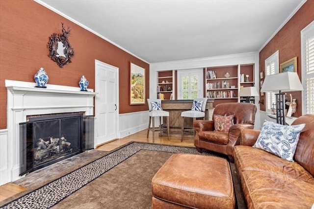 685 Highland St, Marshfield, MA 02050 - living room with a fireplace, crown molding, built in shelves, and a wainscoted wall
