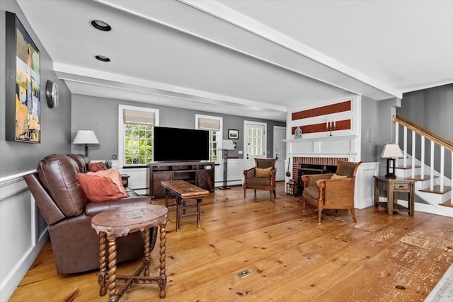 685 Highland St, Marshfield, MA 02050 - living room featuring stairs, light wood-style floors, a brick fireplace, and a baseboard heating unit