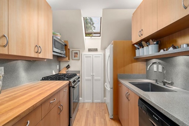 37 Waverly Unit 37, Brookline, MA 02445 - kitchen with appliances with stainless steel finishes, a sink, decorative backsplash, open shelves, and light wood-style floors