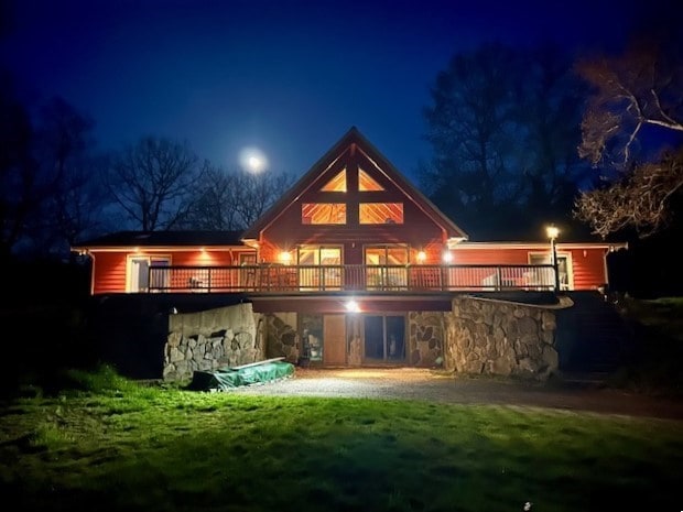 back house at twilight with a lawn