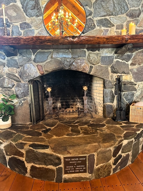 interior details with hardwood / wood-style floors and a stone fireplace