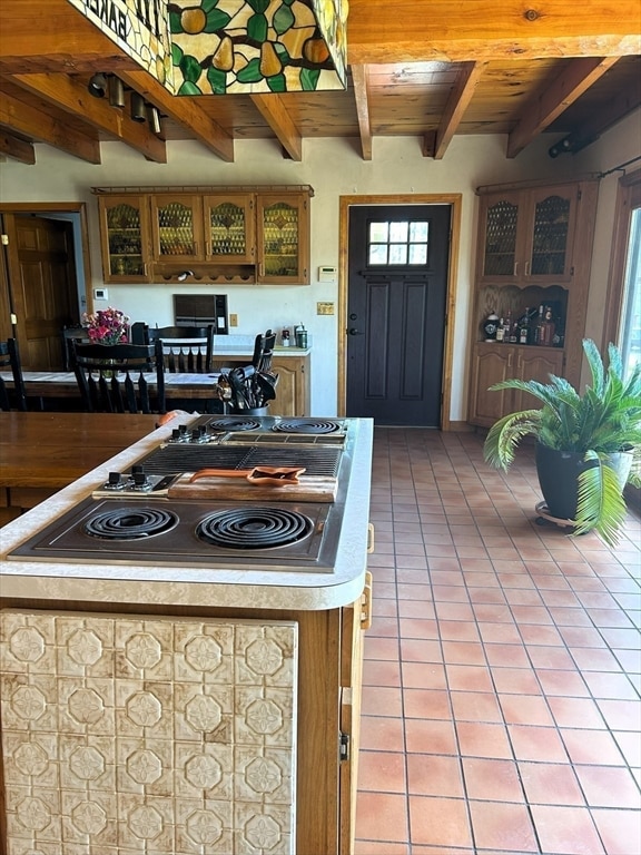 kitchen featuring wooden ceiling, beam ceiling, and tile flooring