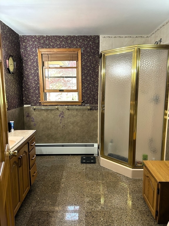 bathroom with a baseboard radiator, vanity, and a shower with door