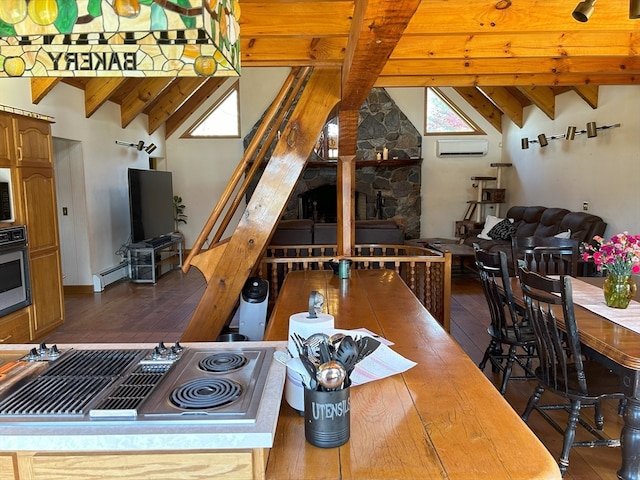 kitchen with vaulted ceiling with beams, a healthy amount of sunlight, baseboard heating, and an AC wall unit