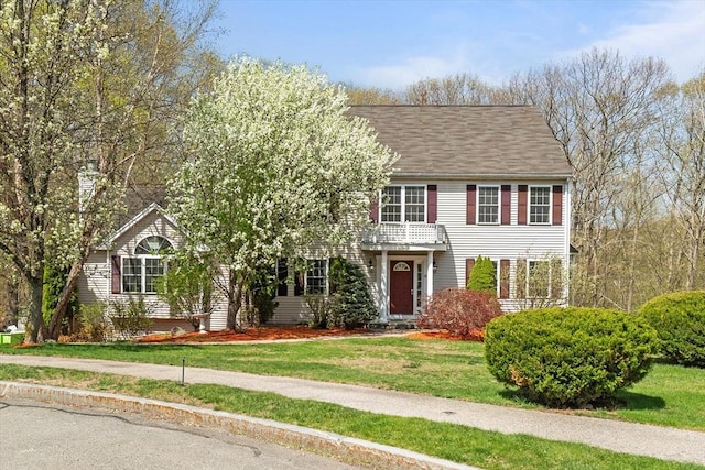 view of front of home featuring a balcony and a front yard
