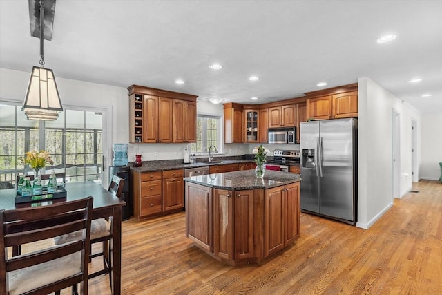 kitchen featuring recessed lighting, appliances with stainless steel finishes, brown cabinetry, and a sink