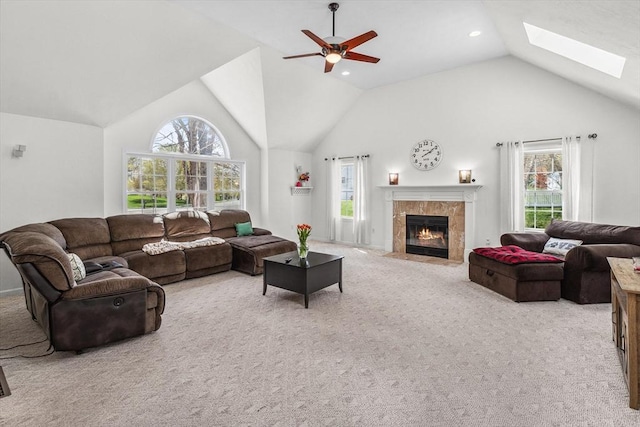 living room with a skylight, a healthy amount of sunlight, carpet, and a tile fireplace