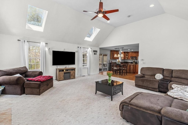 living area featuring a skylight, high vaulted ceiling, ceiling fan, and recessed lighting