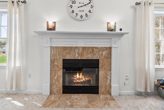 room details with carpet floors, baseboards, and a tiled fireplace